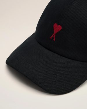 Close-up of a black cap brim with a small red embroidered heart and letter A.