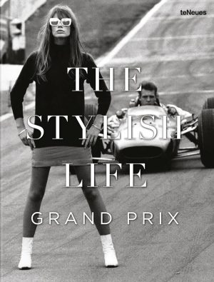 Fashion magazine cover with a model in a black dress and white boots, standing beside a vintage race car; bold title reads 'THE STYLIST LIFE GRAND PRIX' and 'teNeues' logo.
