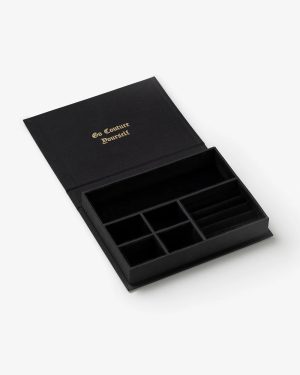 Open black jewelry organizer with multiple compartments; gold text on the lid reads 'Go Couture Yourself'.
