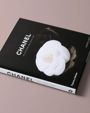 Chanel hardcover book with a black cover and a white camellia on top, spine reads 'CHANEL Collections'.
