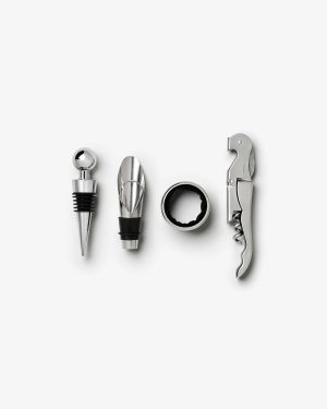 Set of stainless steel wine accessories: stopper, pourer, foil cutter, and corkscrew arranged in a row