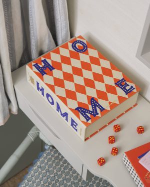 Orange-and-cream diamond-patterned box on a white shelf with several red dice scattered nearby.