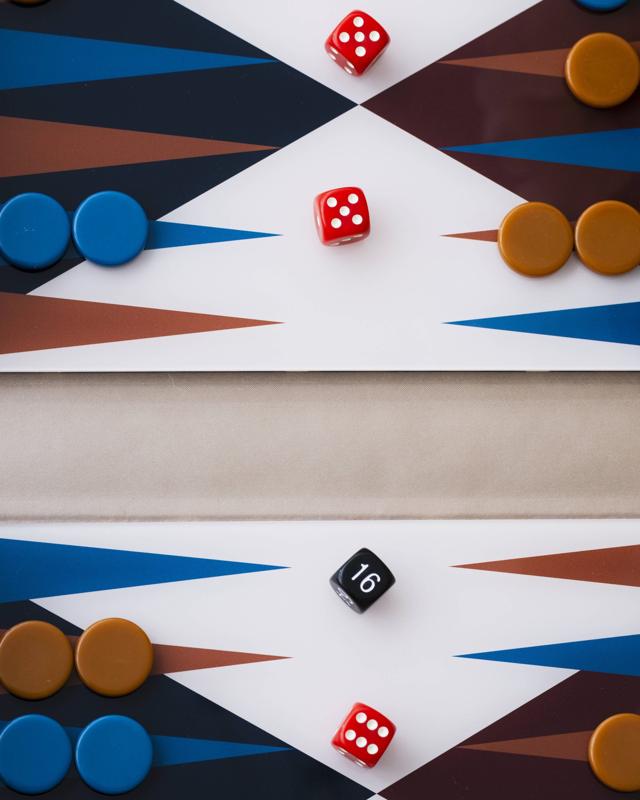 Image 209 - New Trend Two red dice resting on a white diamond of a geometric board, surrounded by blue and orange game pieces on a color-blocked background.
