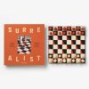 Image 212 - New Trend Orange book cover with the word 'SURE ALIST' and a small chessboard photo in the center; next to it a square chessboard with red and cream pieces and a few pieces on the edges.