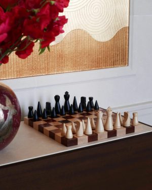 Two chess boards with black and white pieces arranged on a table, with a red bouquet blurred in the foreground.