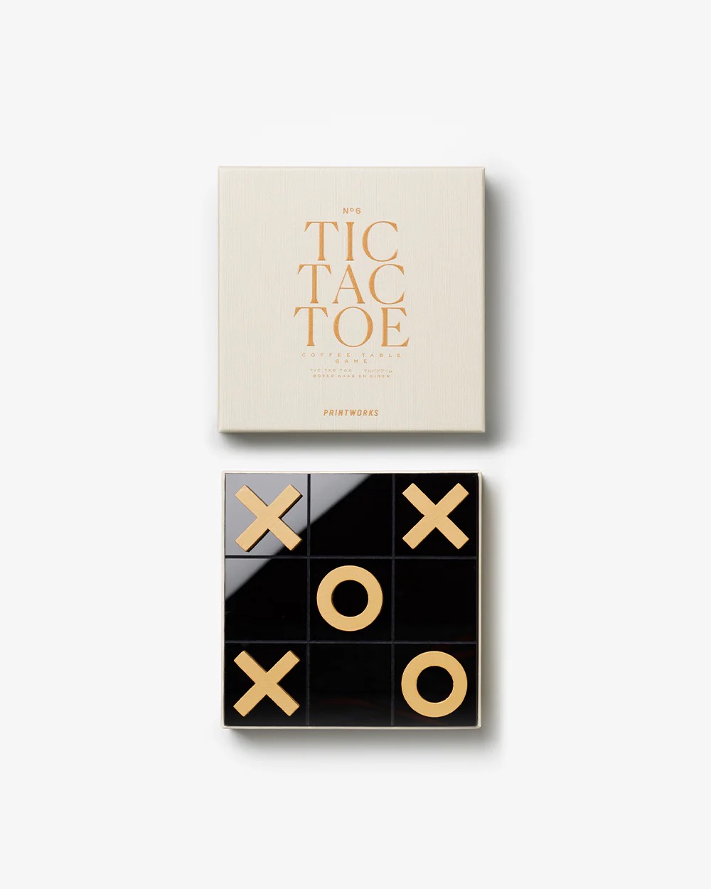 Image 239 - New Trend Cream-colored box with 'TIC TAC TOE' text on the lid; below it a black tic-tac-toe board with gold X and O game pieces visible.
