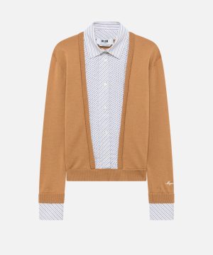 Camel-colored cardigan over a light blue striped button-down shirt with cuffs showing.