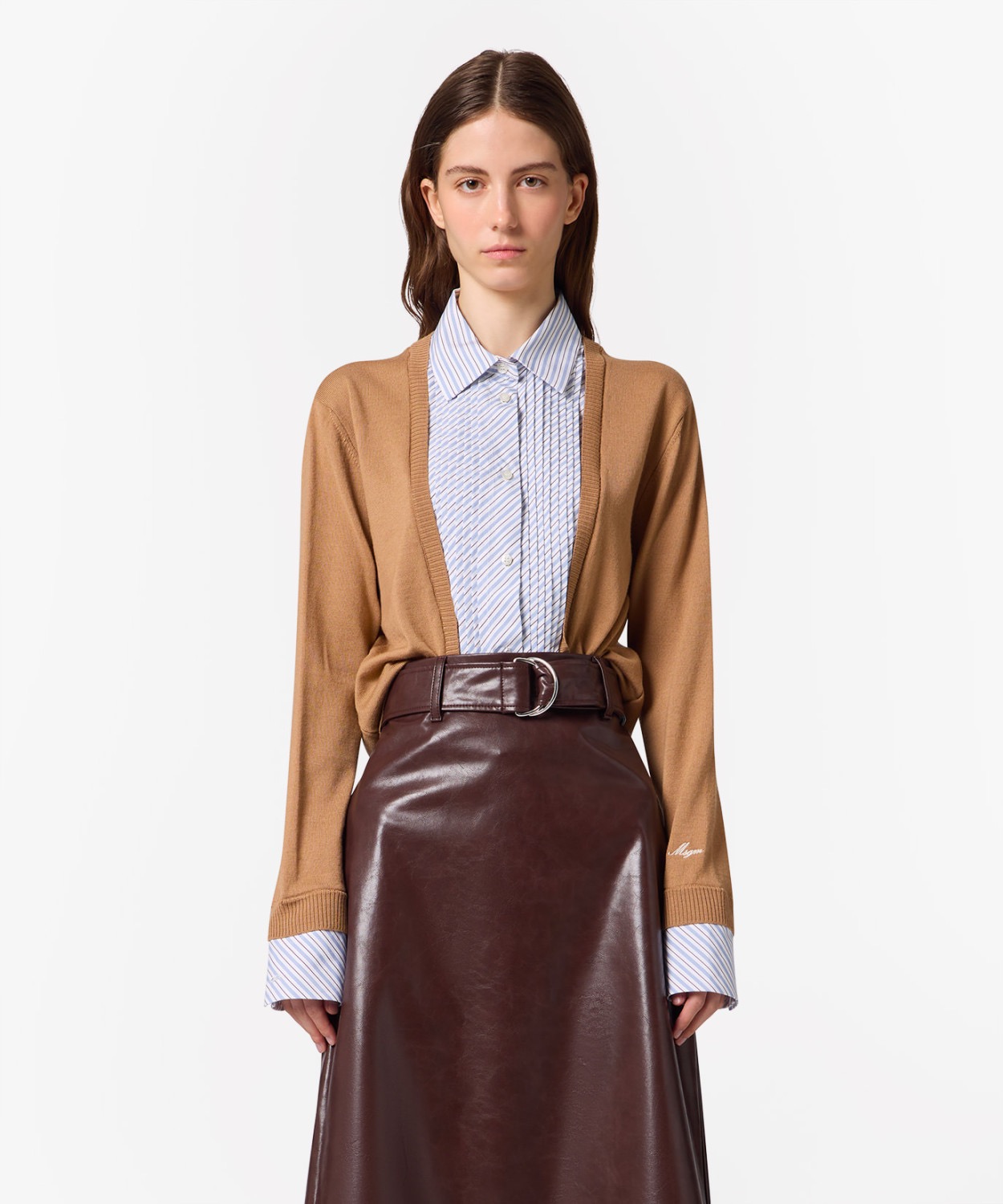 Image 249 - New Trend Model wearing a camel cardigan over a blue striped button-down shirt and a brown leather midi skirt with a belt.
