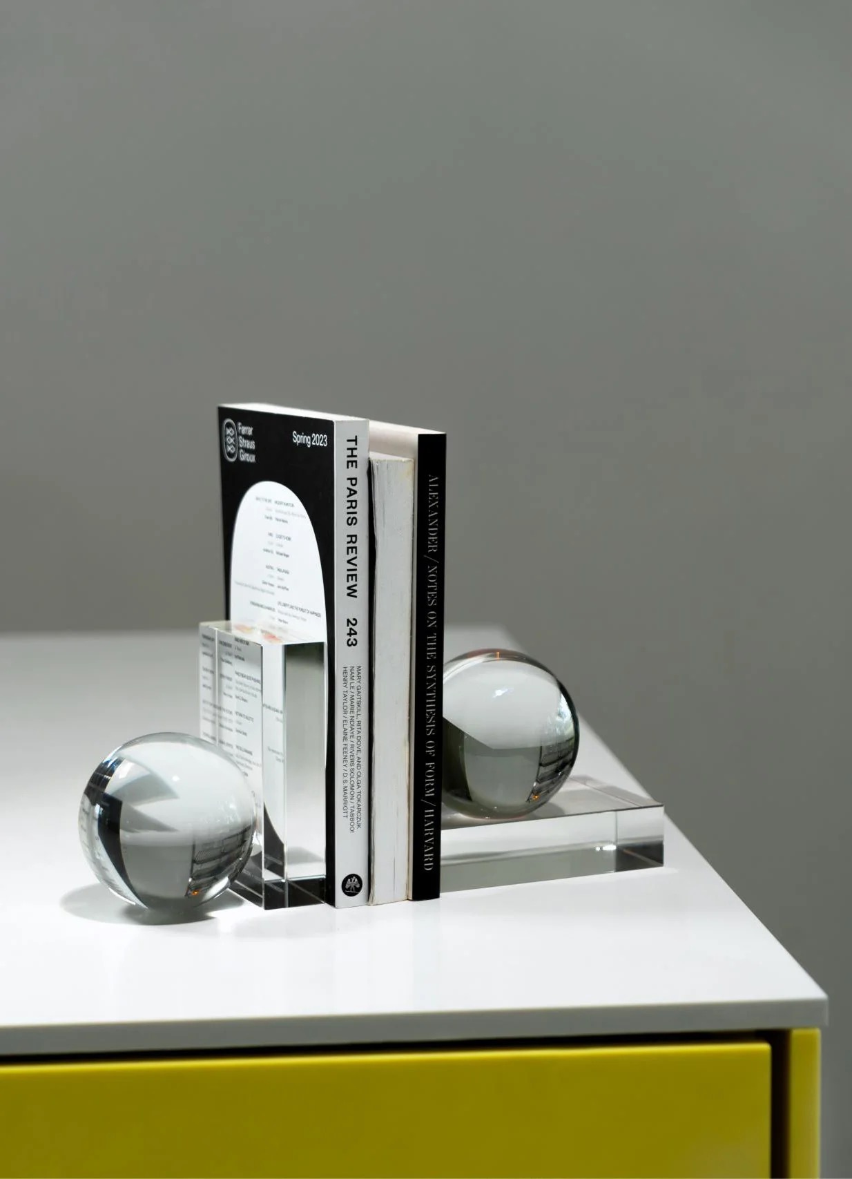 Image 266 - New Trend Stack of black-and-white books with glass spheres on a white table, minimalist still-life arrangement.