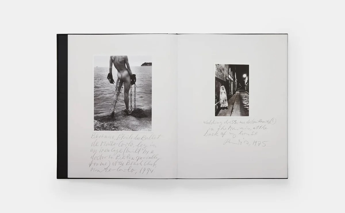 Image 3 - New Trend Open book showing two black-and-white photographs with handwritten captions on white pages; left image depicts a nude figure by the water with chains, right image shows a street scene with a figure in a coat.