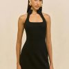 Image 414 - New Trend Woman wearing a black halter dress with a square neckline, standing against a light beige backdrop.