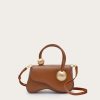 Image 434 - New Trend Brown leather handbag with two large gold-toned spheres attached to handles, on a light beige background