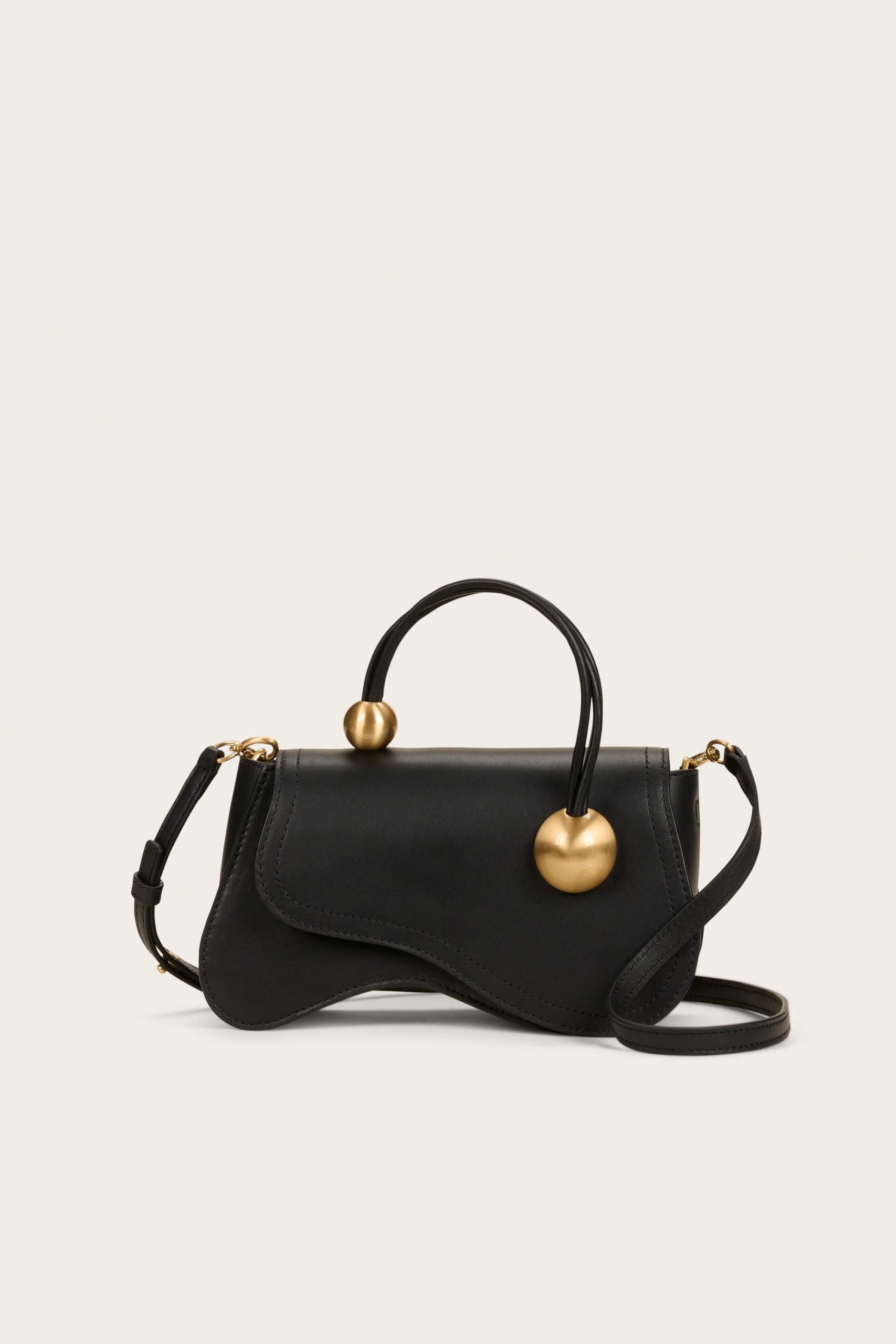 Image 442 - New Trend Black leather handbag with gold spherical accents on the handles, set against a light neutral background (crossbody strap visible).