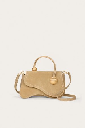Beige leather handbag with a curved top handle and gold hardware on a light background.