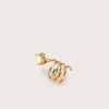 Gold-toned spiral ring with a leaf-shaped end, photographed on a pale beige background.