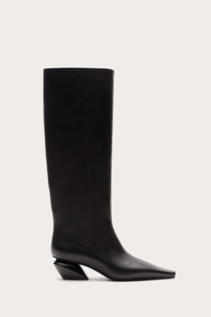 Black knee-high leather boot with a chunky heel photographed against a light beige background, side view