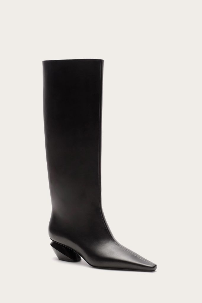 Black knee-high leather boot with a squared toe and low heel on a pale background.