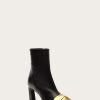 Black knee-high/ankle boot with a chunky heel and a gold-tone buckle detail on the vamp
