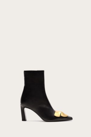 Black leather ankle boot with a gold-tone buckle detail across the vamp and a high sculpted heel