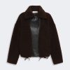 Brown teddy-bear fleece coat with a black leather front panel and drawstring hem.