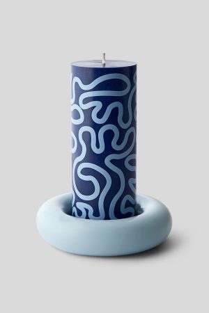Blue pillar candle with abstract light-blue swirls, placed on a pale blue ring-shaped candle holder against a gray background