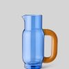Image 570 - New Trend Blue glass pitcher with an amber-orange handle on a light gray background, viewed from the side.