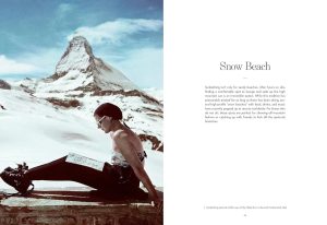 Person wearing sunglasses sits on a snow-covered ledge reading a map, with a snowy mountain peak in the background.