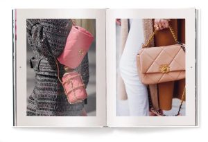 Open fashion book showing two pink Chanel handbags: a small quilted pouch with a chain and a larger quilted shoulder bag with a gold chain accessory.